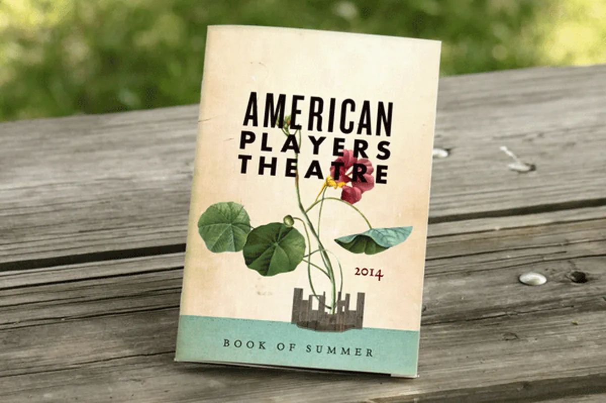 American Players Theatre Book of Summer program standing on a wooden picnic table