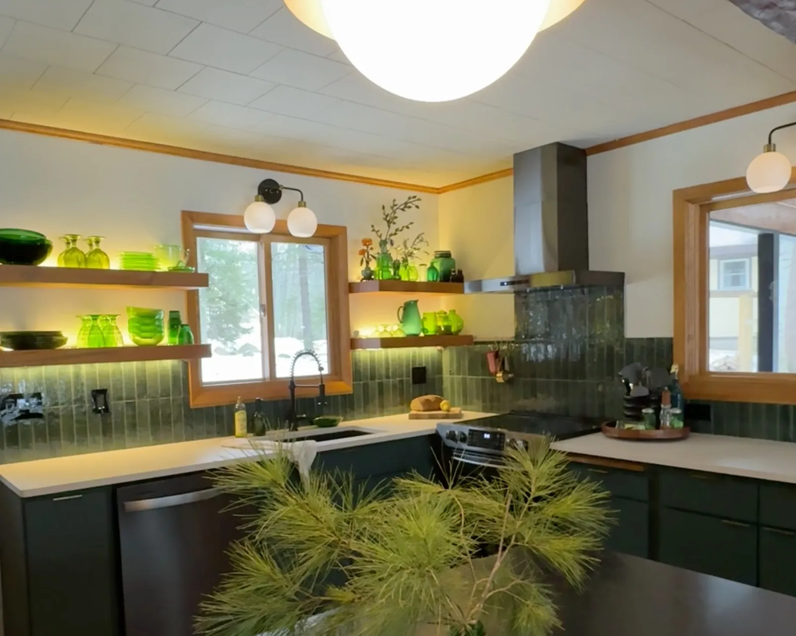 Kitchen after the remodel, sink wall with open shelves and green tile