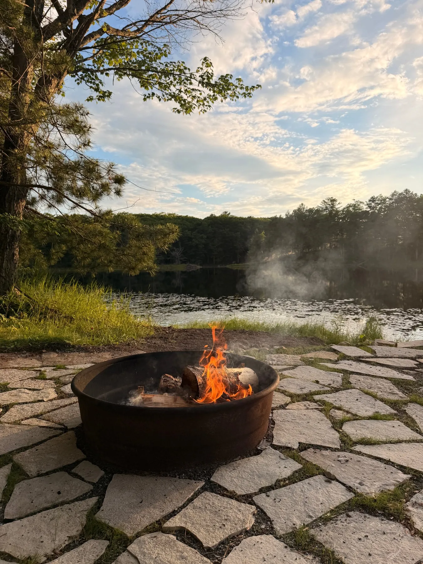 Fieldstone fire pit at the edge of the lake at dusk